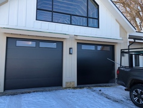 The alt text for the image is: House with black garage doors.